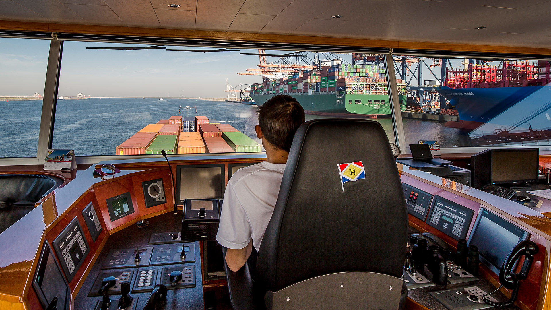 Captain in wheelhouse sails into the port of Rotterdam